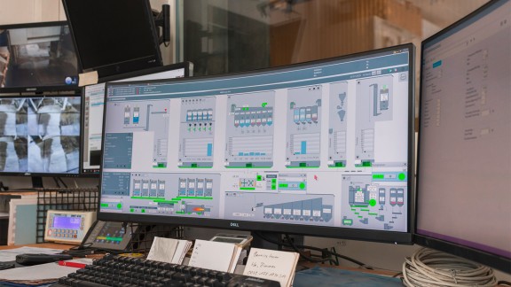 View of several computer screens showing control system graphics.