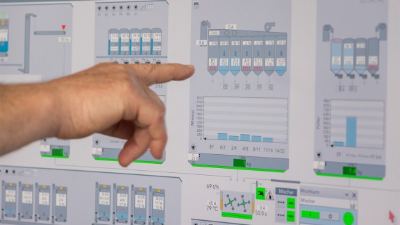 A hand with a finger pointing at a control function on the computer screen.