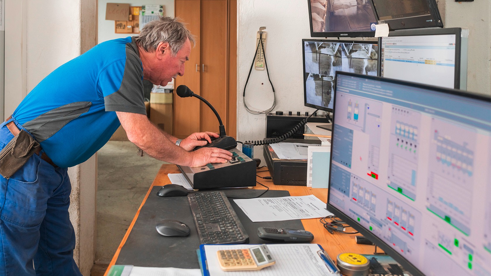 The mixing foreman bending over a desk, looking at the computer screen.