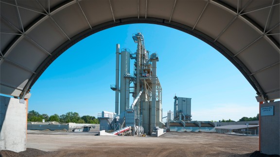 Asphalt mixing plant with the curved roofs of the material storage areas
