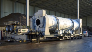 Tambor de secado bajo el sol y delante la planta de mezcla asfáltica.