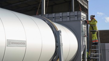 Un operario con ropa de obra trabaja en el tambor de secado.